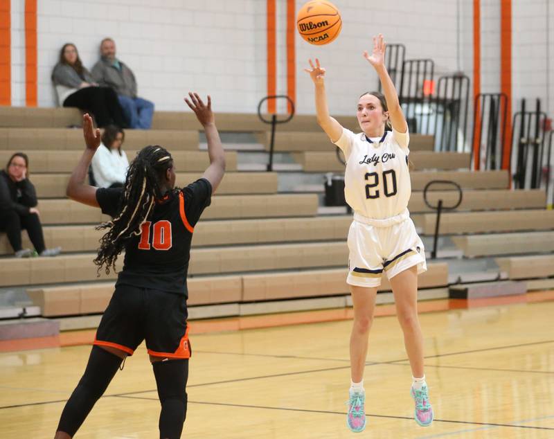 Marquette's Kaitlyn Davis sinks a shot over Peoria Manual's Cameeya Wade during the Falcon-Irish Thanksgiving Tournament on Monday, Nov. 18, 2024 at Flanagan High School.
