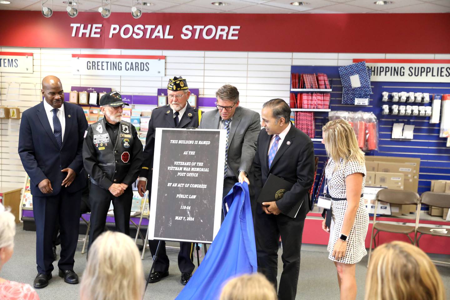 (Left to right) USPS Post Office Operations Manager Greg Harris, Wayne Kirkpatrick, chairman of Rolling Thunder Chapter 2, Capt. Dennis Larson, chaplain, Jeff Drake, acting district manager for USPS Illinois 1, U.S. Rep. Raja Krishnamoorthi and St. Charles Mayor Lora Vitek unveil a plaque during a naming ceremony of the East Side Post office in St. Charles on Wednesday, July 17, 2024. The post office has been renamed the Veterans of the Vietnam War Memorial Post Office.