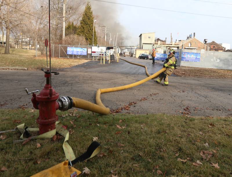 A firefighter hooks up a hose to a hydrant on the south side of the Carus Chemical plant on Wednesday, Jan. 11, 2023 in La Salle.