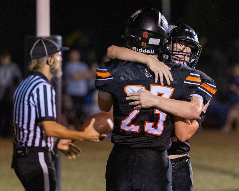 Brezdyn Simons (23) of FCW hugs teammate Emmett Horaney (22) after touchdown on Friday, Sept. 26, 2025, at Woodland School in rural Streator.