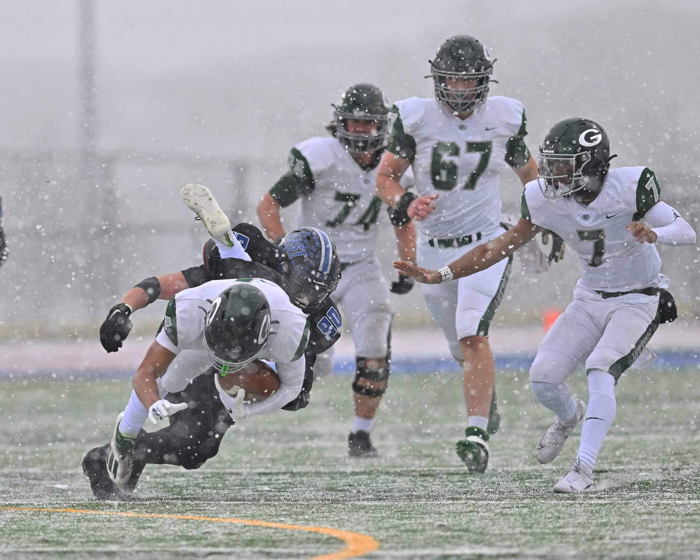 Lincoln-Way East's David Wuske (90) tackles Glenbard West's Julius Ellens (4) during the IHSA Class 8A semifinals on Saturday, November 19, 2022, at Frankfort.