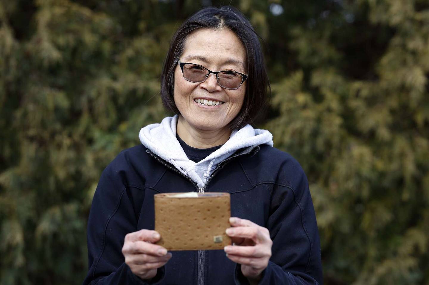 Julia Hsia holds a replacement wallet that her mother gave her. Hsia lost her wallet in a river in Arizona during a trip in 1995. A man recently found the missing wallet.