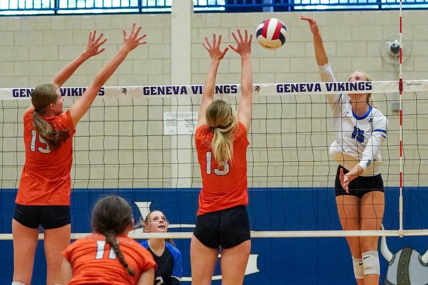 Geneva’s Emma Peterson (15) goes up for a kill attempt against Wheaton Warrenville South's Katie Dragas (15) and Alison Coyne (13) during a DuKane Conference match in Geneva on Tuesday, Sept. 16, 2025.