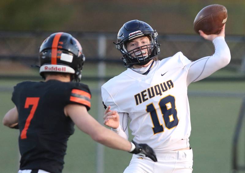 Nequa Valley quarterback Mark Mennecke gets rid of the ball just ahead of the rush by DeKalb's Michael Clayton during their game Friday, April 16, 2021, at DeKalb High School.