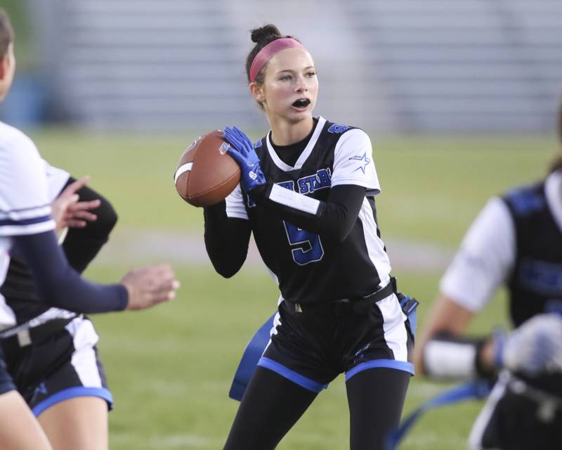 St. Charles North's Olivia Taormina (5) drops back to pass during Oswego East Regional Final flag football game between St. Charles North at Oswego East Thursday, Oct 9, 2025 in Oswego.