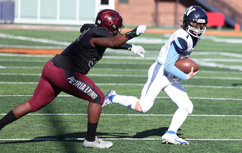 Nazareth's Logan Malachuk gets outside of Peoria's Kevin Roberts during their IHSA Class 5A state championship game Saturday, Nov. 26, 2022, in Memorial Stadium at the University of Illinois in Champaign.