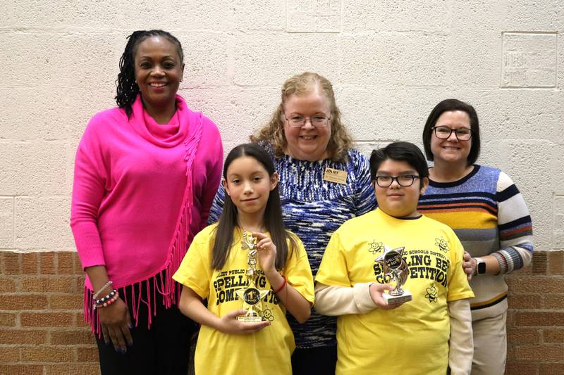 Lynne Thigpen Elementary School Principal Dr. Teresa Woodard, Joliet Public Schools District 86 Superintendent Dr. Theresa Rouse, and Carl Sandburg Elementary School Academic Advisor Nina Easto pose with first place spelling bee winner and second place winner Isaac Ruiz.