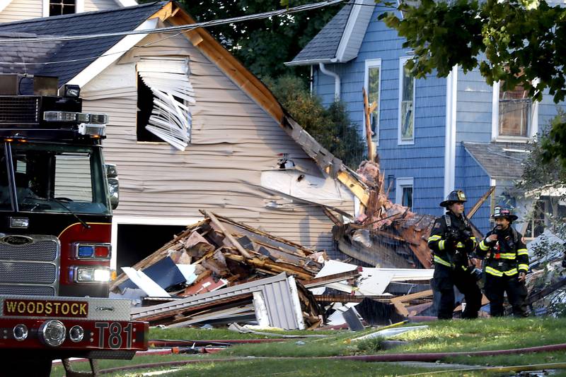 Firefighters next to a pile of ruble in the 300 block of Lincoln Avenue in Woodstock Monday, Oct. 9, 2023, after an explosion following suspected gas leak in the area.