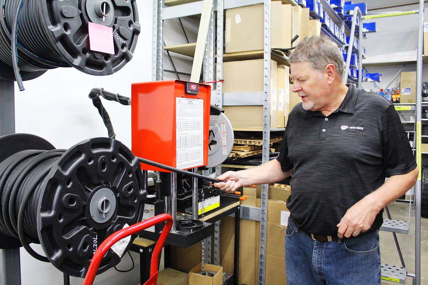 Marc Blanc, president of Schulz/Carquest of Monroe, Wisc., displays a hydraulic hose assembly system at Carquest Auto Parts' Dixon location.