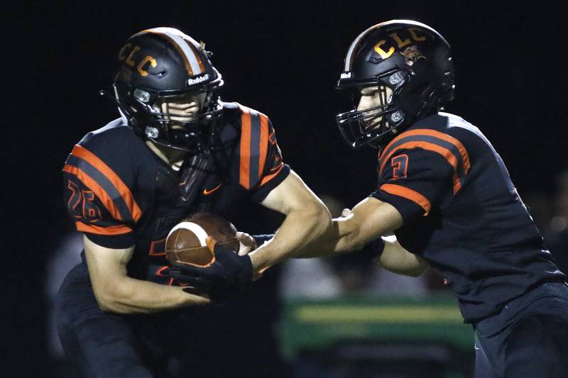 Crystal Lake Central quarterback Colton Madura, right, hands the ball off to Brent Blitek during their week 2 football game against Jacobs on Friday, Sep. 3, 2021 at Crystal Lake Central High School in Crystal Lake.