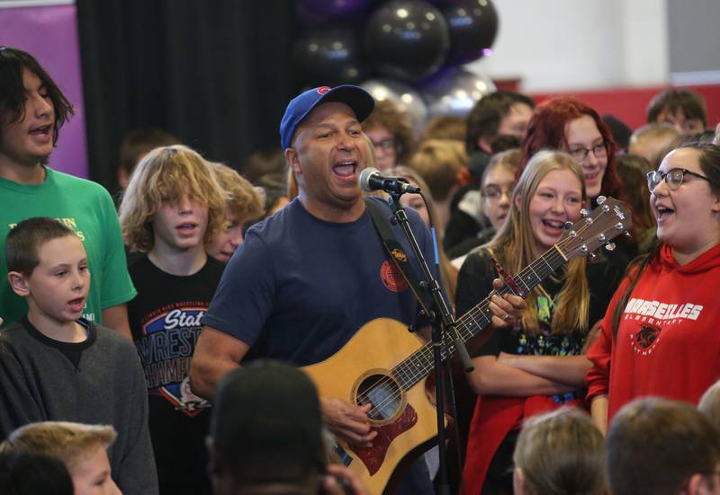 Tom Morello sings with students at Marseilles Elementary School on Thursday, Nov. 30, 2023. Morello is best known for his tenure with the rock bands Rage Against the Machine and Audioslave. Morello grew up in Marseilles before making it to the major music industry.
