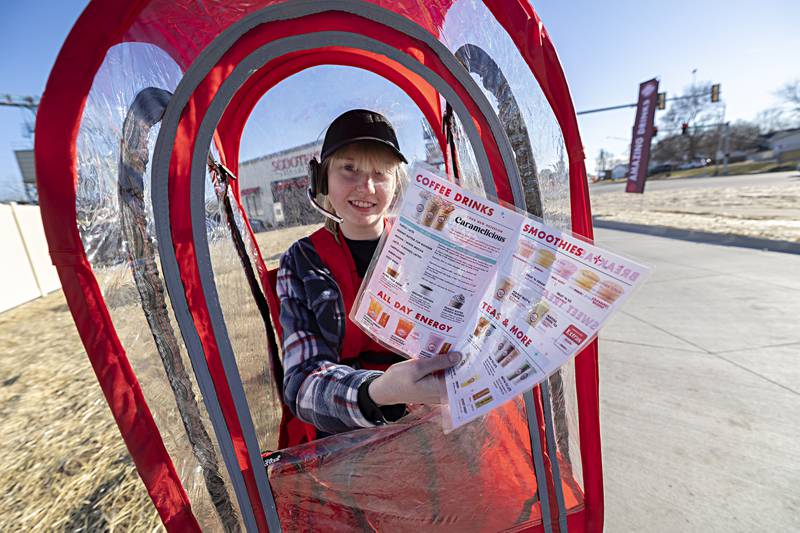 Rachael Bennett shows off the Scooter’s menu Tuesday, Dec. 12, 2023 at their new location in Rock Falls. The drive-thru coffee/smoothie restaurant also serves pastries and sandwiches.