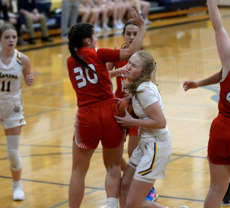 Polo's Camrynn Jones (4) draws a foul as she drives to the basket against Oregon's Mya Engelkes (30) during Tuesday, Dec. 5, 2023 action at Polo High School.