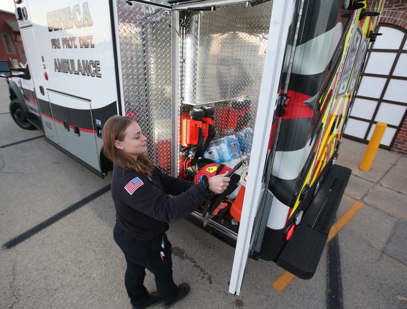 EMT Emma Margarella inspects one of the side doors of the Seneca ambulance the Seneca Fire Protection and Ambulance District building on Friday, Oct. 18, 2024 in Seneca.
