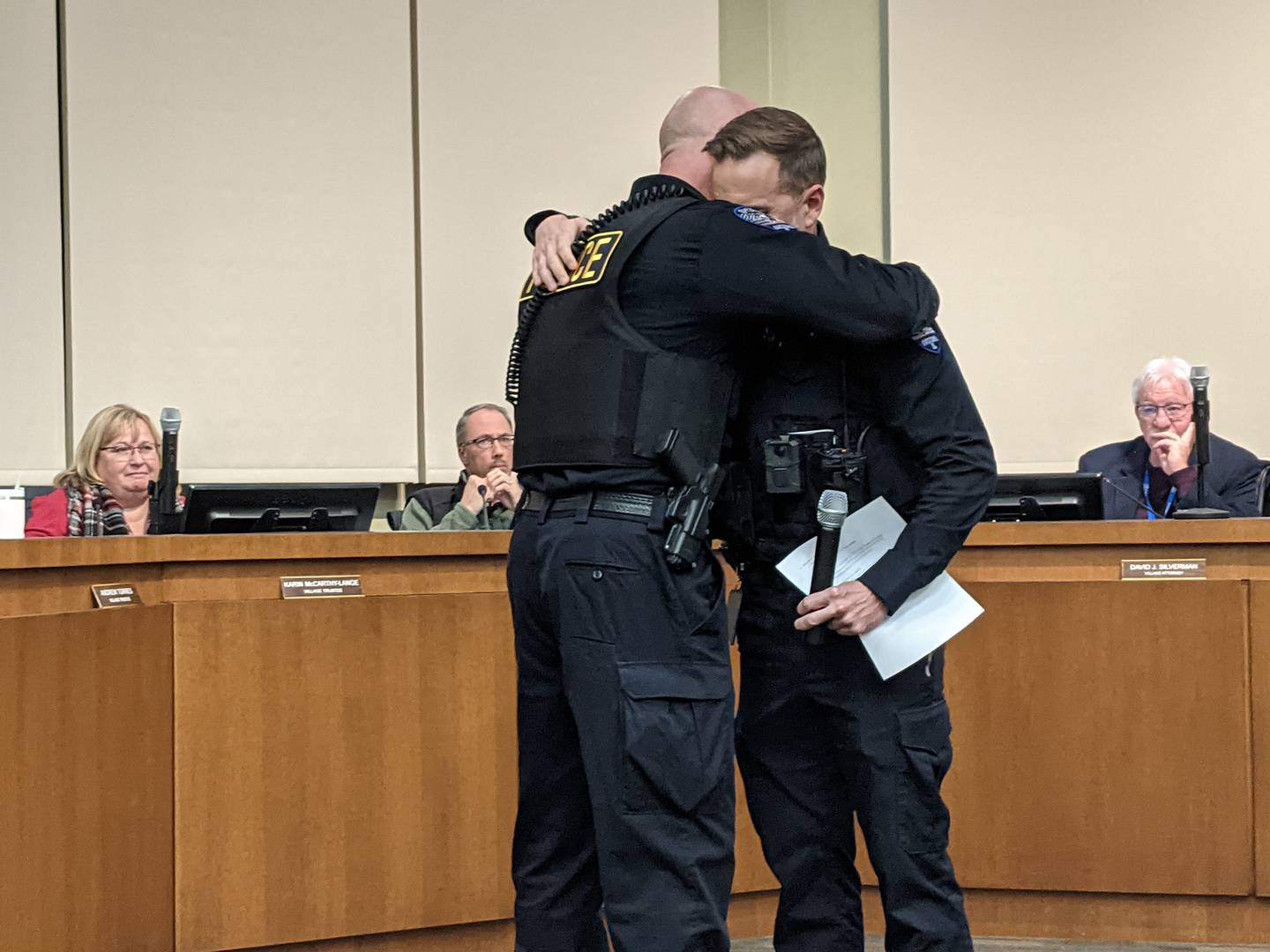 Oswego Police Chief Jason Bastin, right, gives retiring Oswego Deputy Police Chief Chris Biggs, left, a hug during the Dec. 10 Oswego Committee-of-the-Whole meeting.