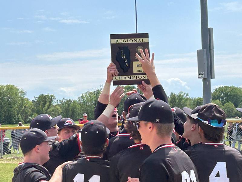 Fulton's Jacob Huisenga holds the regional trophy high in the air as he celebrates with his teammates following the Steamers' 7-4 win over Forreston at the 1A Amboy Regional on Saturday, May 24, 2025.