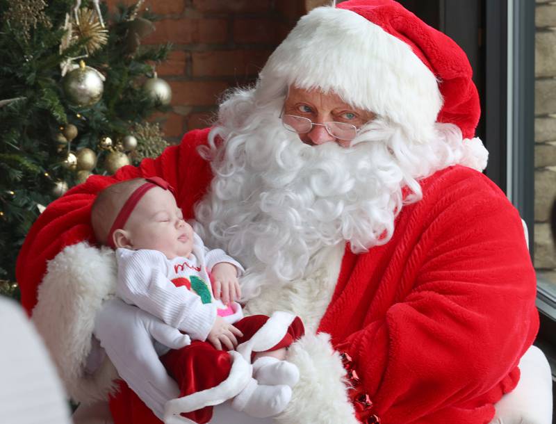 Adeline Vagasky falls asleep on Santa Claus's lap during the Miracle on First Street at the Auditorium Ballroom on Saturday, Dec. 6, 2025 in La Salle.