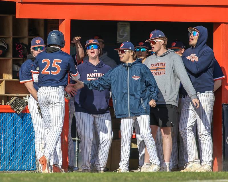 Oswego's Kam Jenkins (25) is greeted at the dugout after scoring during baseball game between Plainfield South at Oswego on Monday, April 14, 2025 in Oswego.