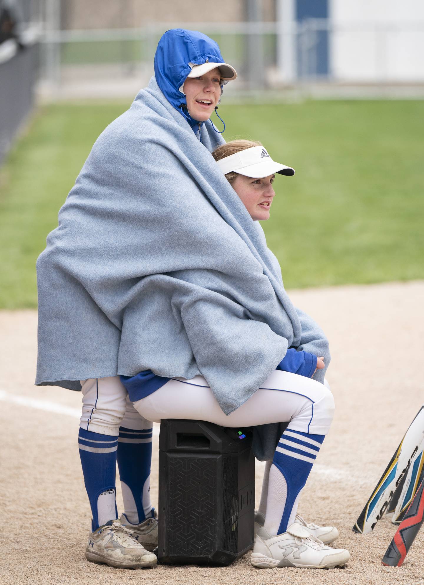 Burlington Central's Alyssa Becker, right, and Rylie Duval keep warm during their game against Prairie Ridge on Wednesday, April 27, 2022 at Burlington Central High School. Temperatures were in the upper 30s during the game. Ryan Rayburn for Shaw Local