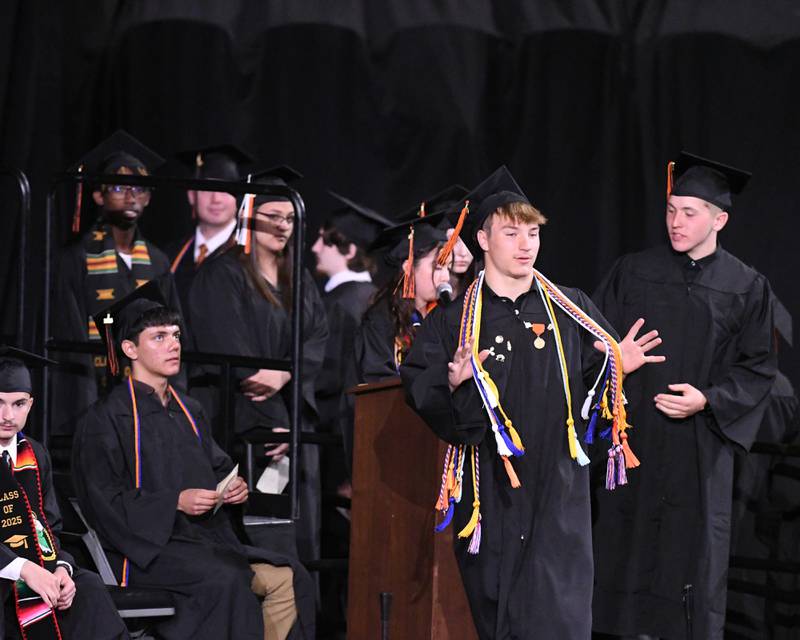 DeKalb High School senior Sean Kolkebeck shows off all his achievements as he walks across the stage to receive his diploma on Saturday, May 24, 2025, during the Class of 2025 Commencement ceremony held at the NIU Convocation Center in DeKalb.