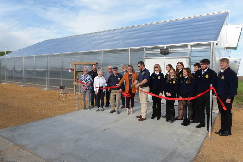 Alec Wetzell and Stephanie Schultz, Polo High School ag teachers and FFA advisors,, cut the ribbon offically opening the school'a new greenhouse on Wednesday, May 1, 2024. Standing with Wetzell are Polo FFA members and members of the community who helped support the creation of the new 42'x72' structure.