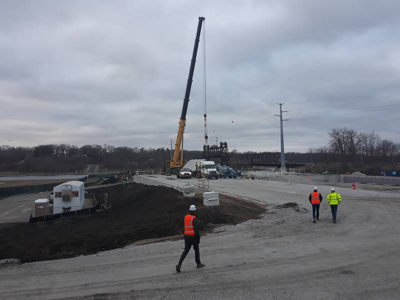 Construction crews work Friday, March 19, 2023, at erecting the first pre-cast wall at the new Ottawa riverfront YMCA facility. The crews were unable to hoist the wall Friday because of windy conditions, but it is ready to be erected as soon as possible.