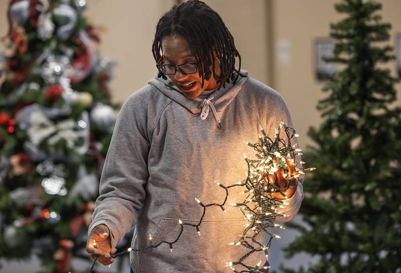 Devon Neal strings lights on a tree sponsored by the Whiteside County Senior Center Sunday, Nov. 17, 2024, for Rock River Hospice’s Festival of Trees. The center’s tree had a gingerbread theme with decorations handmade by clients.