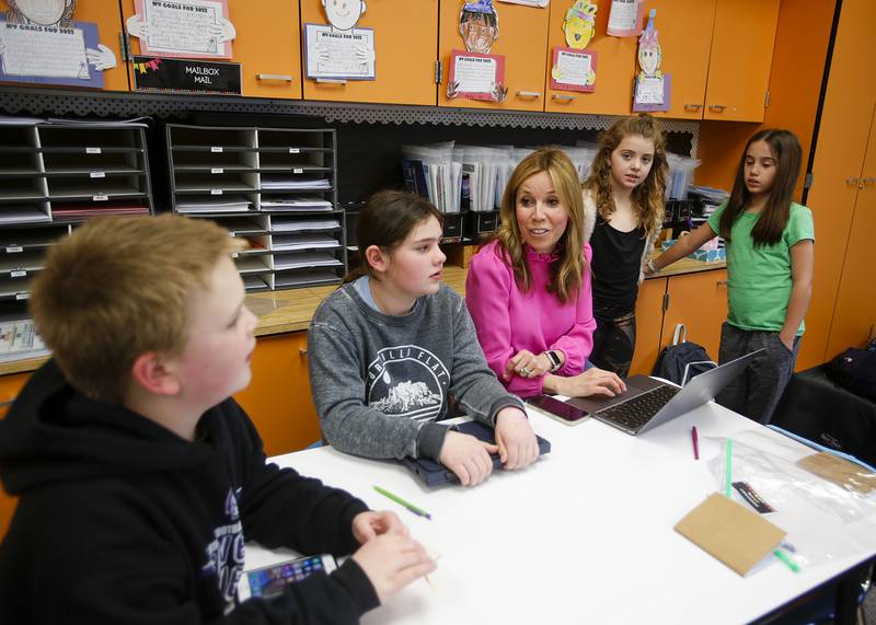Christine Reynolds works with students during the Podcast Club at Henry Puffer Elementary School in Downers Grove on Thursday, March 24, 2022.