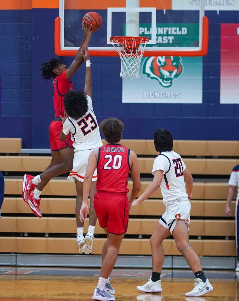 West Aurora's Terrence Smith (5) plays the ball above the rim against Oswego’s Dasean Patton (23) during a basketball game at Oswego High School on Friday, Dec 1, 2023.