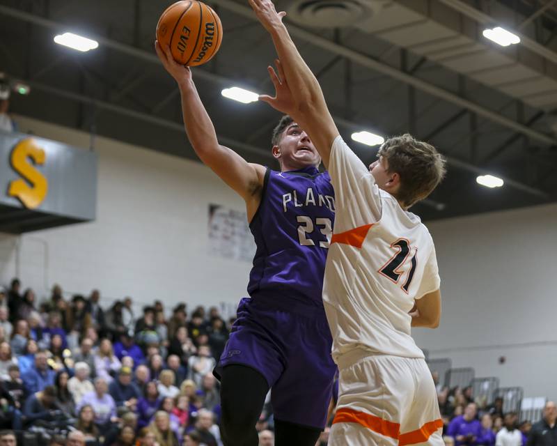 Plano's Cooper Beaty (23) puts up a shot over Sandwich's Ej Treptow (21) during their basketball game between Sandwich at Plano Tuesday, Jan 27, 2026 in Sandwich.