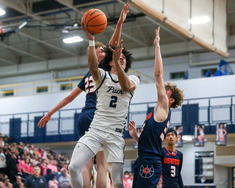 Oswego East's Jacsen Tucker (2) puts up a shot between the defense during their basketball game between Oswego at Oswego East, Feb 13, 2026 in Oswego.