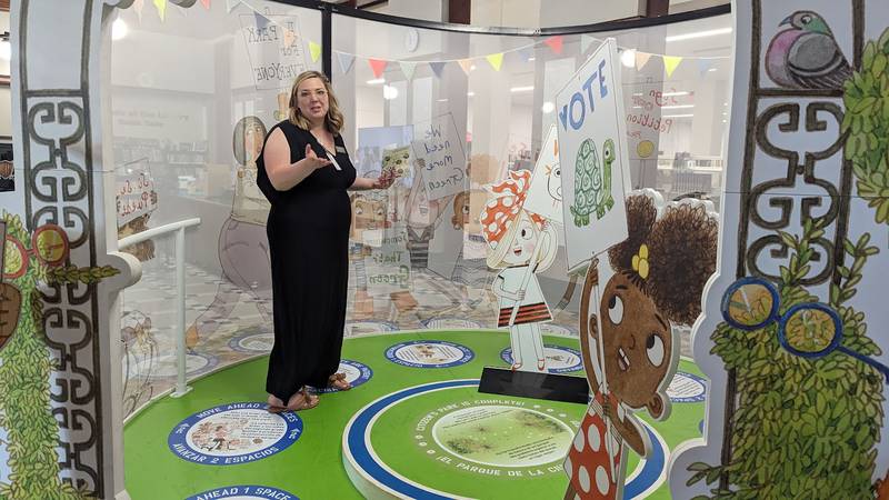 Mallory Hewlett, communications manager at the Joliet Public Library, shows one of the interactive displays in the “The Questioneers: Read. Question. Think. PLAY!” exhibit on Wednesday, June 21, 2023. This exhibit is based on the Questioneers book series authored by Andrea Beaty and illustrated by David Roberts. This traveling exhibit featuring the Questioneers characters opened June 16 at the Ottawa Street branch of the Joliet Public Library and is available during library hours through July 29.