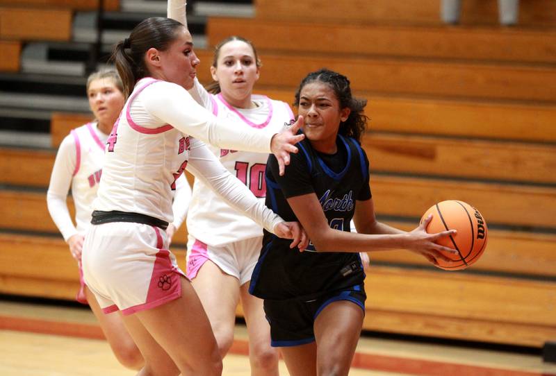 St. Charles North’s Sydney Johnson tries to pass around Batavia’s Hallie Crane during a game on Monday, Dec. 16, 2024 in Batavia.