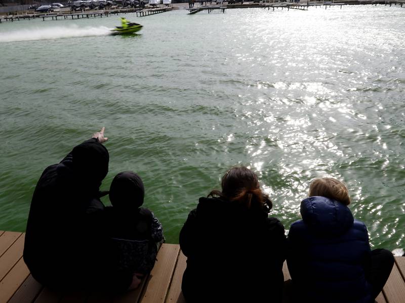 People watch as the Fox River is dyed green during the ShamROCKS the Fox Festival in McHenry on Saturday, March 16, 2024.