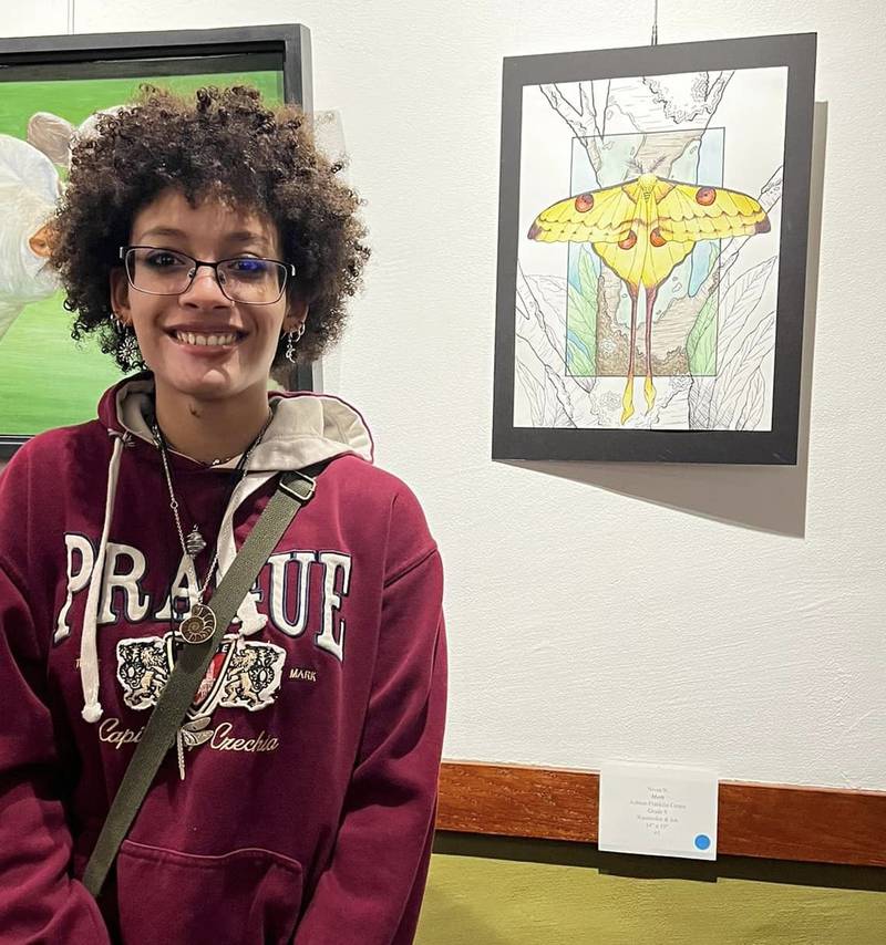 Nivea Noon, a freshman at Ashton-Franklin Center, poses next to her artwork, “Moth,” during the opening reception of Woodlawn Arts Academy’s 15th annual Student-Teacher Art Exhibit. The exhibit runs through April 26 and is free and open to the public.