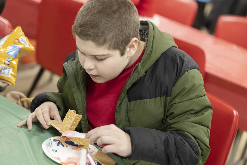 Josiah Garza, 12, gets creative with his cookie decorating by putting together a gingerbread house Wednesday, Dec. 11, 2024.