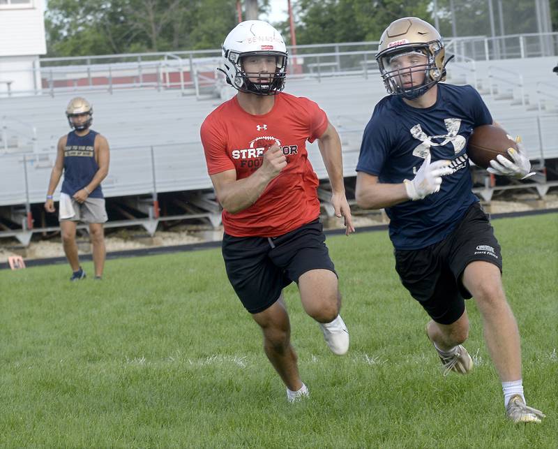 Marquette ballcarrier Tom Durdan tries to evade Streator defender Christian Benning during the teams' joint practice/7-on-7 Monday, July 11, 2022, at the SHS Athletic Fields.