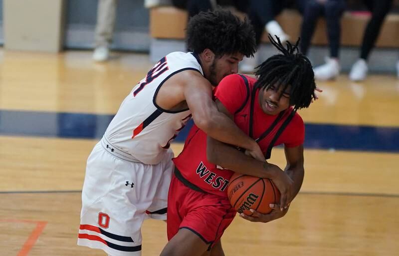 West Aurora's Terrence Smith (right) rebounds the ball against Oswego’s Taiden Thomas during a basketball game at Oswego High School on Friday, Dec 1, 2023.