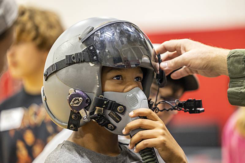 Challand Middle School eighth-grader Treyvion Durham tries on pilot Tom Kittler’s combat aviator helmet Friday, Oct. 20, 2023. Kittler, of Northbrook, came in to talk about the career during the Regional Office of Education’s annual Pathway Playground. The event brings in eighth-graders from all over the area to explore career options.
