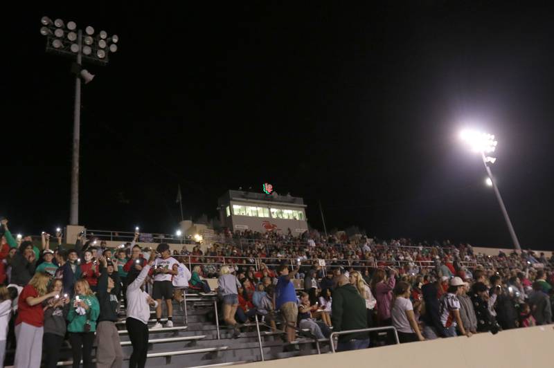 Fans hold up lights on their cell phones after a stadium light went out during the game between L-P and Metamora on Friday, Sept. 5, 2025 at Howard Fellows Stadium.