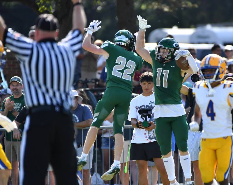 Glenbard West’s Chase Cavan (11) celebrates with teammate Max Bakken after scoring a touchdown after a catch during a game against Lyons Township on September 27, 2025 at Glenbard West High School in Glen Ellyn.