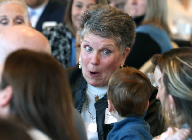 Michelle Schulz, who owned and operated Kar-Fre Flowers along with her sister Kris Wrenn (not pictured), has some fun with one of the younger members of her family, as she and her sister are introduced as the winners of the Clifford Danielson Outstanding Citizen Award during the Sycamore Chamber of Commerce Annual Meeting Thursday, March 6, 2025, at St. Mary's Catholic Church in Sycamore.