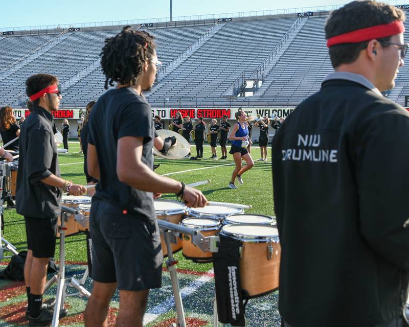 A DeKalb Corn Classic runner makes their way through Huskie Stadium with Northern Illinois University's marching band making a path for them on Sunday, Sept. 29, 2024, in DeKalb.