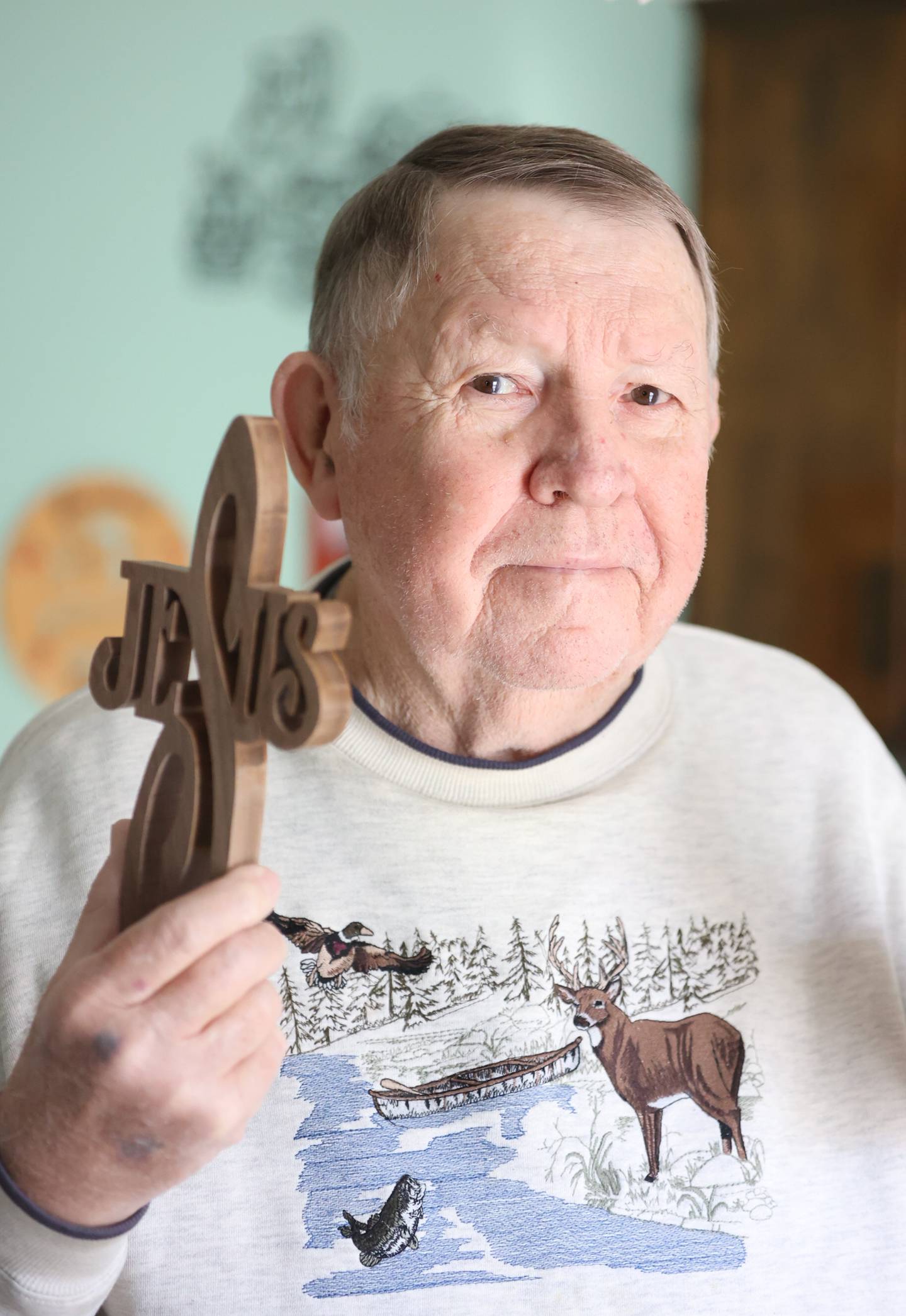 Bob Figurowski holds the same hand made cross he brought to New York shortly after 9/11 to hand out. Thursday, Jan. 20, 2022 in Joliet.