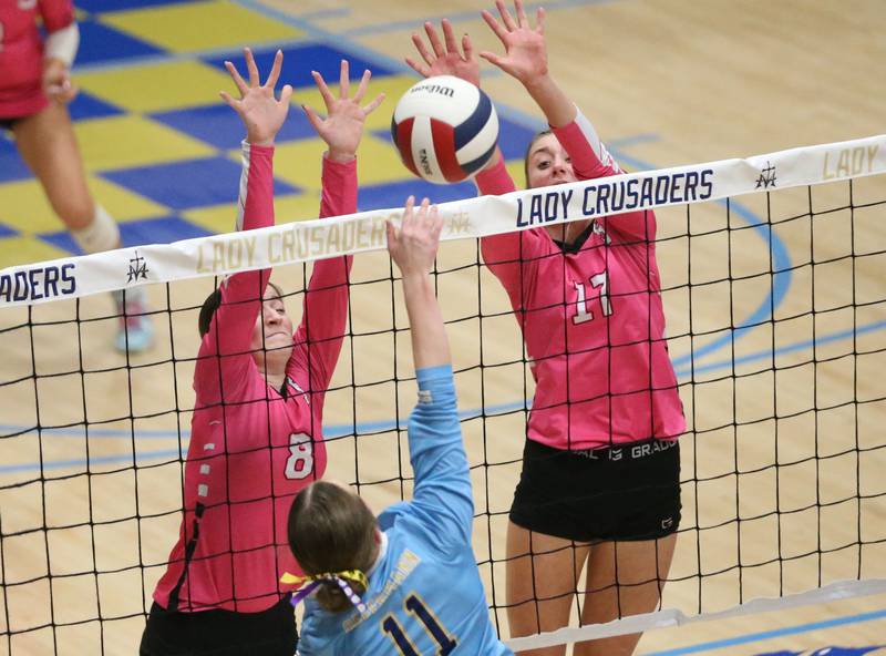 Serena's Rebekah Shugrue and teammate Kendall Whiteaker block a spike from Marquette's Ava Offermann on Wednesday, Oct. 22, 2025 in Bader Gymnasium at Marquette High School.