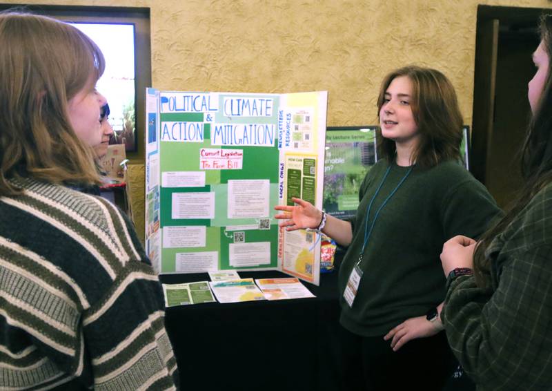 Zoe Crain, a junior at Northern Illinois University from Park Ridge, talks about climate change by her group’s display Thursday, April 18, 2024, during Earth Fest at the Egyptian Theatre in DeKalb. The event, in honor of Earth Week, was presented by DeCarbon DeKalb, in partnership with NIU.
