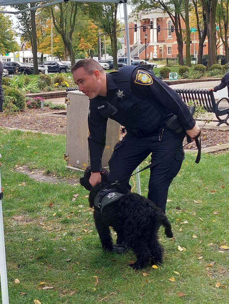 Ottawa officer Tyler Brewer pets an excited Rookie, the police department's new therapy dog, on Saturday, Oct. 14, 2023, at Washington Square in Ottawa during the Out of the Darkness Walk event.