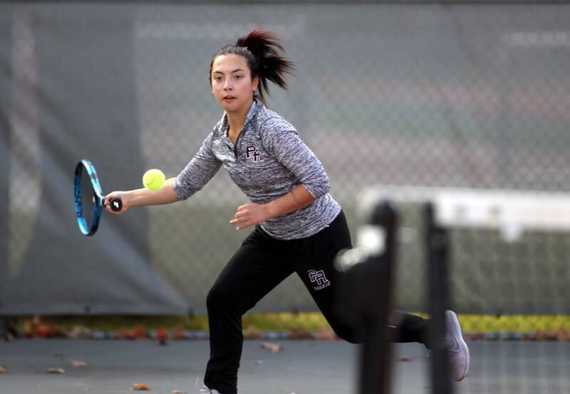 Prairie Ridge’s Kelsey Collins goes after the ball in a match with doubles partner Madeleine Bartmess (not pictured) during the first day of the IHSA state tennis tournament at Palatine High School on Thursday, Oct. 20, 2022.