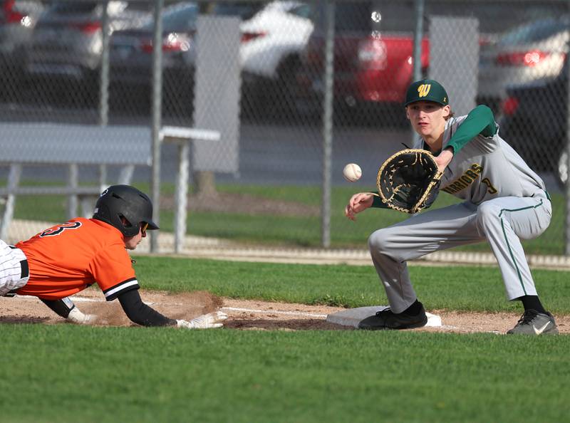 DeKalb's Caden Smith dives back safely into first base as Waubonsie Valley's Jacob Quinn catches the throw on a pickoff attempt Monday, April 20, 2026, during their game at DeKalb High School.