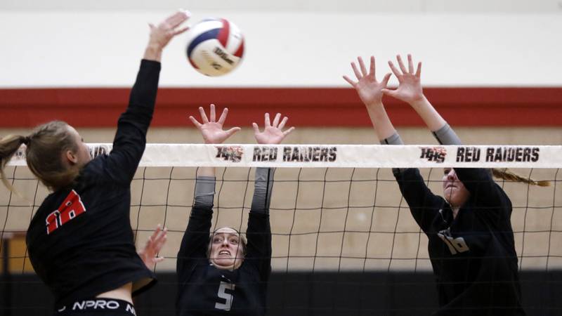 Huntley's Sienna Robertson (left) hits the ball as Prairie Ridge's Grace Jansen (center) and Adeline Grider (right) trie to block the ball during a Fox Valley Conference volleyball match on Tuesday, Oct. 8, 2024, at Huntley High School.
